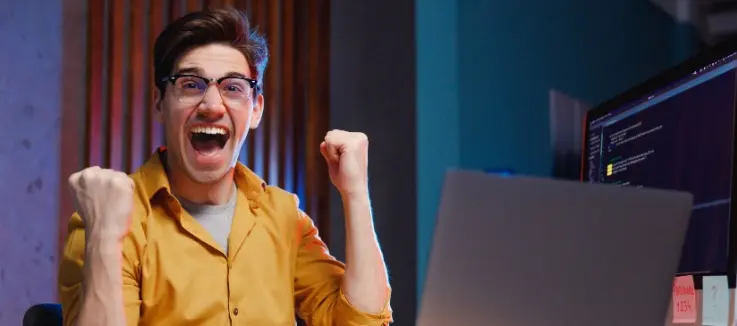 man with a computer in a winning pose 