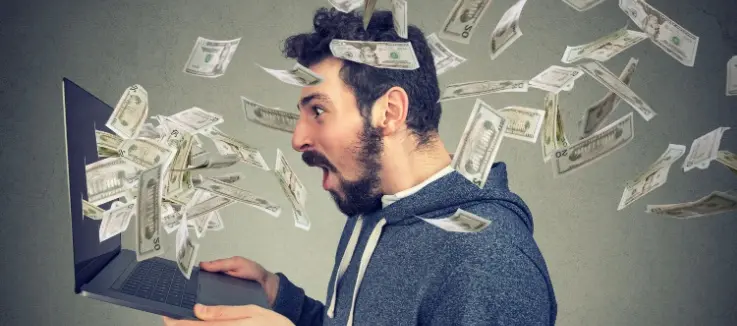 money exploding from a laptop shooting money in the man