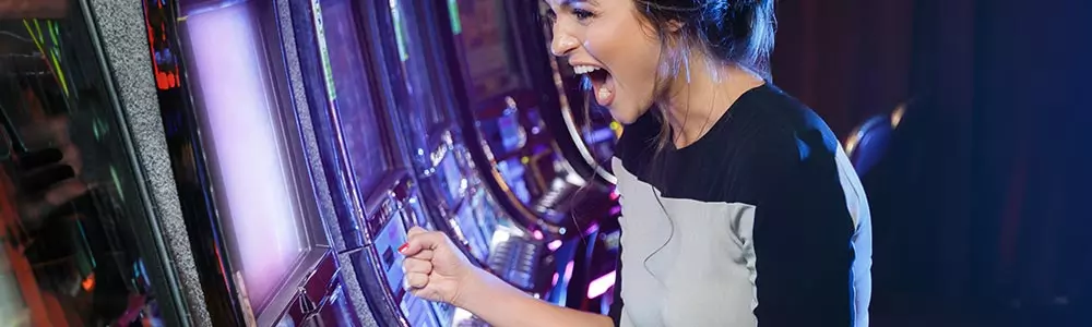 woman celebrating a win playing a slot machine  