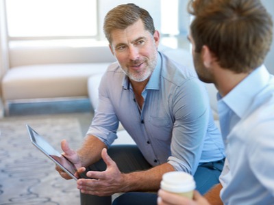 older man in discussion with a younger man  